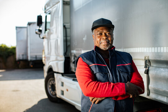 Confident truck driver with arms crossed at loading yard