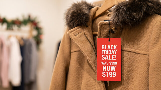 Warm winter coat with large Black Friday sale price tag in a clothing store. Holiday apparel promotion for seasonal shopping, fashion discounts, and retail advertising
