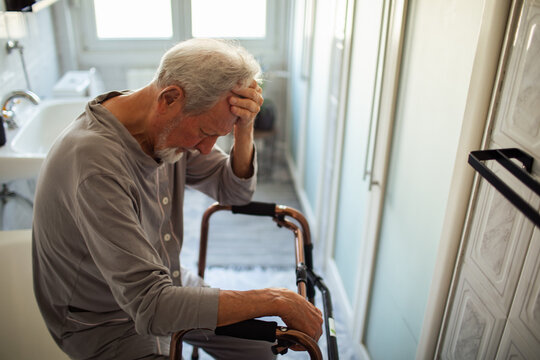 Senior man with walker feeling unwell in bathroom