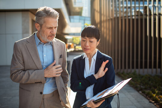 Two business colleagues reviewing report outside office