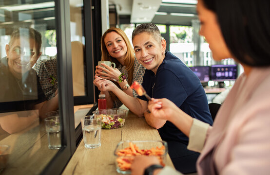 Coworkers sharing healthy lunch in modern office break area