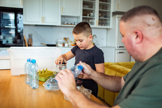 Parent and child sorting plastic recycling in a home kitchen