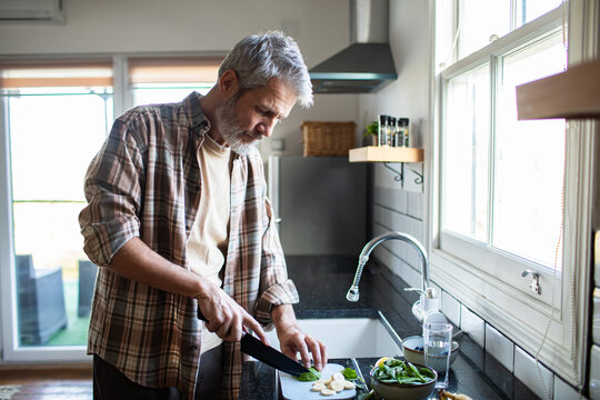 Mature man preparing healthy breakfast in home kitchen