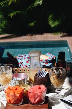 Caf&eacute; da manh&atilde; tropical com caf&eacute;, suco e frutas servido &agrave; beira da piscina