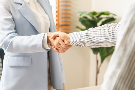 Close up successful job interview and recruitment concept with professional HR manager shaking hands with a selected candidate after a positive career hiring agreement in a bright modern office.