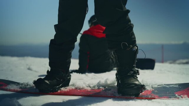 Friends enjoy a winter day snowboarding together on a bright snowy mountain. The stunning mountain landscape provides a perfect backdrop for this active outdoor recreation.