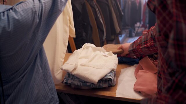 Sheltering Clothing Organization. People Working Together To Arrange Thrifted Clothing Items Neatly