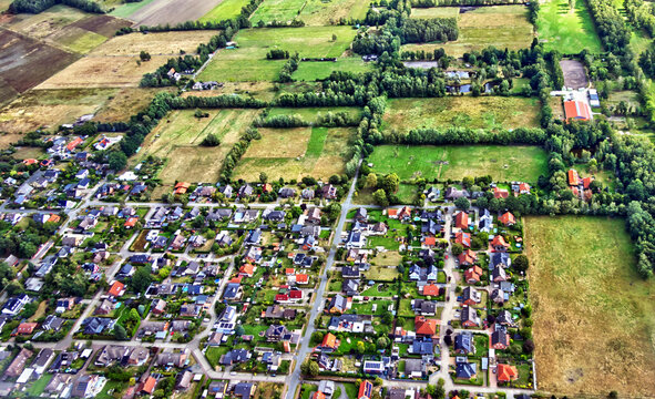 Aerial view of a residential area bordering green fields and farmland, showing urbanization expanding into nature in gifhorn, germany