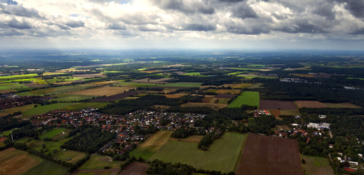 Aerial view of gifhorn, germany, showing rural landscape with fields, forests, and residential areas under cloudy sky