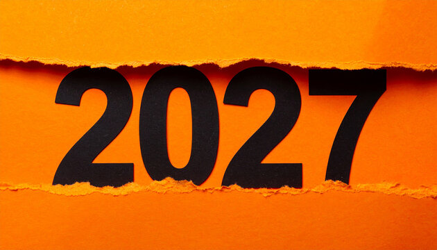 Large black 2027 partially hidden behind ripped vivid orange paper, jagged edges and layered texture, minimalist design. New year. Close-up.
