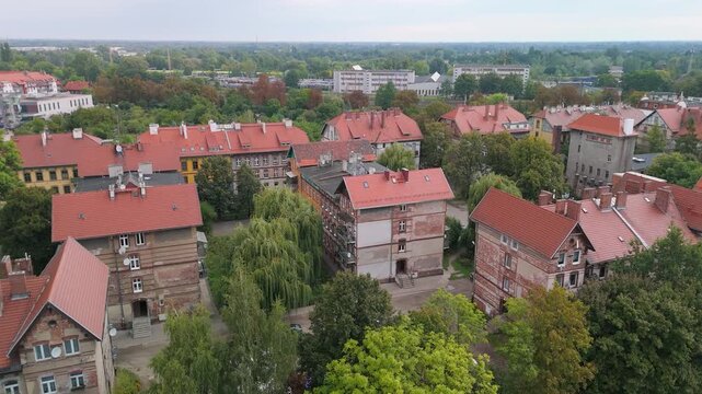 Aerial drone view of historic late 19th-century railway workers' housing in Brochow, Wroclaw, Poland. Old brick residential buildings with red tiled roofs surrounded