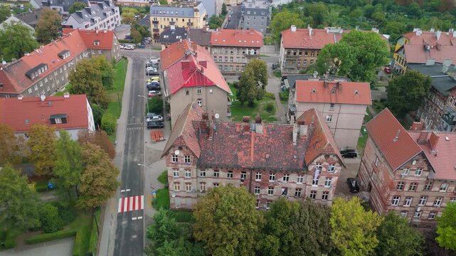 Aerial drone view of historic late 19th-century railway workers' housing in Brochow, Wroclaw, Poland. Old brick residential buildings with red tiled roofs surrounded