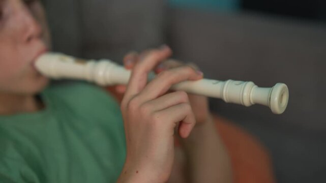 A little boy learns to play the flute at home, practicing with focus and enthusiasm in a cozy, warm setting. A charming scene of early musical exploration, creativity, and childhood growth.