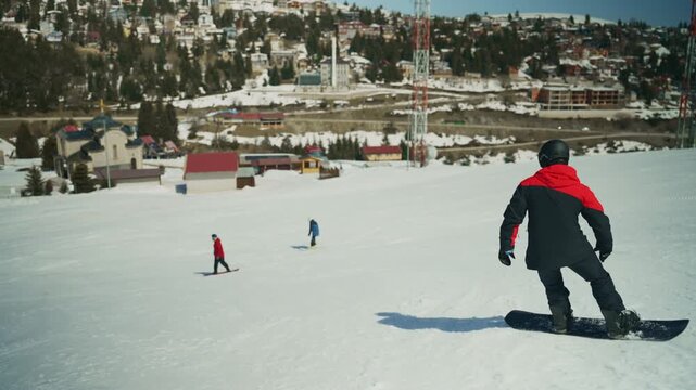 Snowboarders and skiers enjoy a beautiful day on a mountain slope. The scene captures the essence of winter sports recreation.