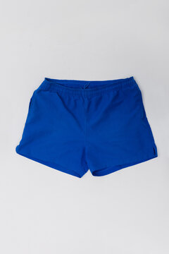 Studio flat lay shot of men's bright blue athletic shorts with elastic waistband on a white background. Ideal for product catalog, apparel mockup, sportswear design, and e-commerce store.