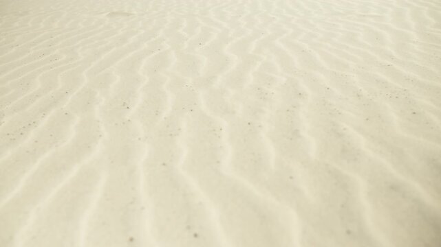 Underwater sand texture with sunlight caustics creating a seamless looping background for vacation and travel concepts