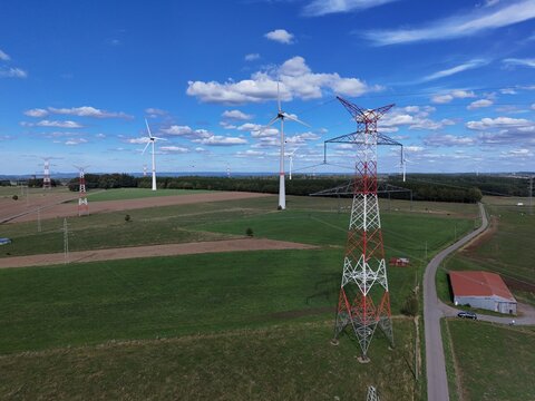 vue a&eacute;rienne panoramique des &eacute;oliennes et des pyl&ocirc;nes &agrave; haute tension &eacute;lectrique qui produisent et  transportent l'&eacute;nergie dans la r&eacute;gion de Bastogne, en Belgique, pr&egrave;s du village de Sibret. 
