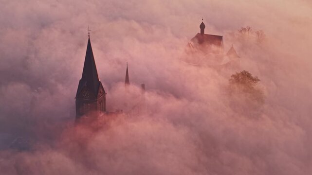 Aerial view of church spire above fog in Kessel, Netherlands.