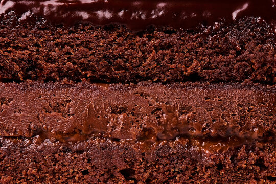 Macro texture of rich layered chocolate cake with creamy fudge frosting and glaze