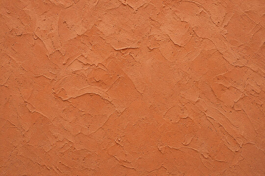Warm terracotta clay plaster wall trowel marks texture background