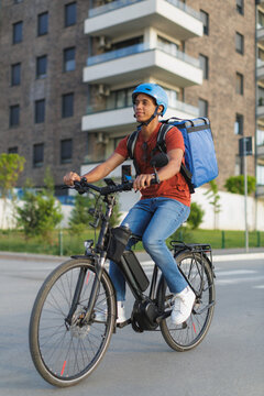 Courier rides electric bicycle and delivers food in urban setting
