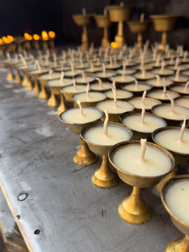 Close-up of rows of Butter lamps lined up at a shrine in a temple, Kathmandu, Nepal