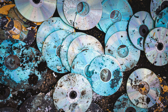 Discarded CDs and DVDs Covered in Dirt and Debris