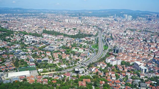 Aerial view of urban landscape featuring highways, residential buildings, and green spaces in a bustling city environment in Istanbul, Turkey 