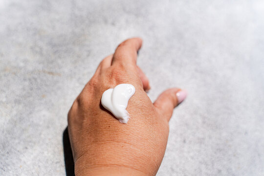 Close-up of Heart shaped SPF cream on woman's hand on a stone table