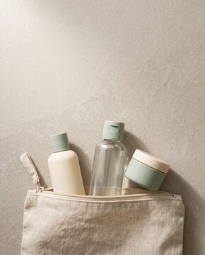 Travel toiletry bottles and jar with an open linen pouch