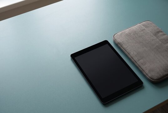 Unbranded tablet and padded sleeve on muted teal
