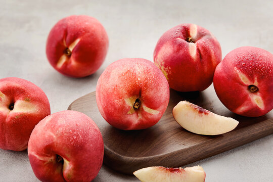 Close-up of Fresh whole Peaches and peach slices on a Wooden chopping Board