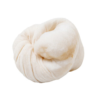 A delicate piece of off-white muslin cloth gathered into a rounded knot shape showcasing natural folds and a soft texture against a plain backdrop