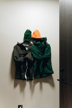 Outdoor jackets and beanies drying on electric clothes dryer