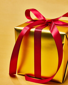 Elegant Gold Gift Box With Red Ribbon