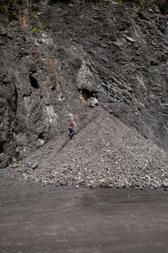 Worker climbing coal excavation pile at open pit