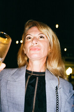 Woman raising a glass at an evening gathering
