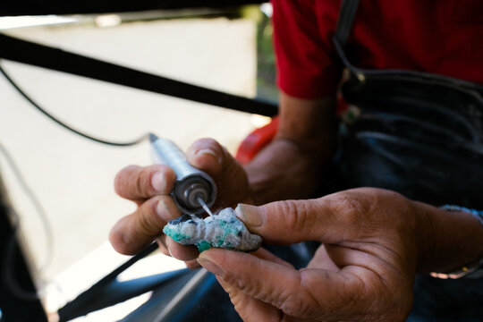 Hands crafting precious emerald gem stone jewelry