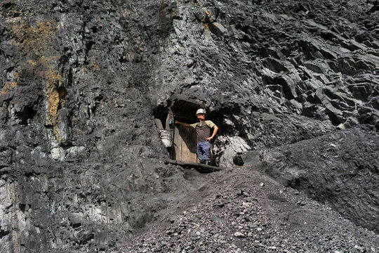 Miner standing at coal mine entrance working outdoors