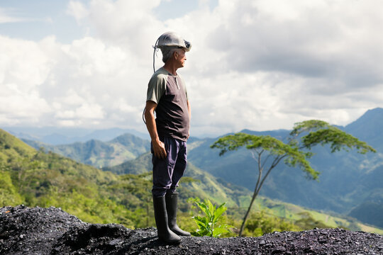 Miner man standing on large coal pile