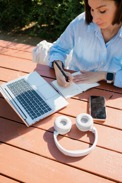 Woman Writing Task List in Agenda During Outdoor Work Session