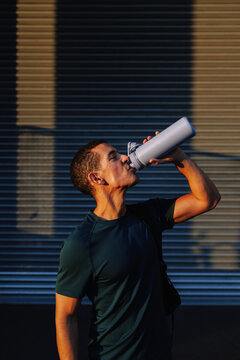 Young man drinking water during sport activity