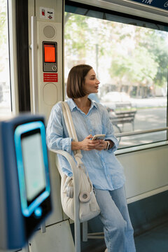 Woman inside a tram is using a smartphone