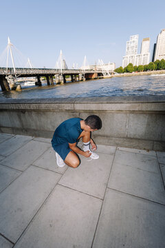 Young man tying shoelace preparing for a run in London