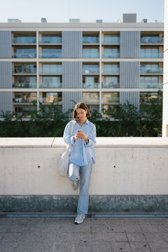 Stylish Woman Texting on Mobile Phone in Urban Residential Zone