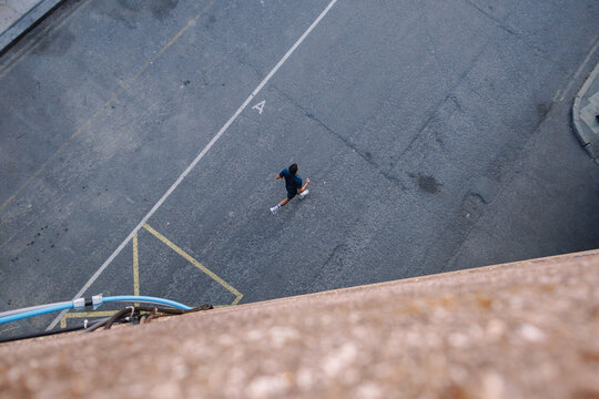 Young man running on urban city street overhead