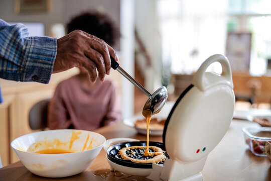Pouring waffle batter into a home waffle maker