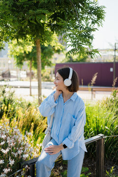 A woman listen music with headphones in a city park