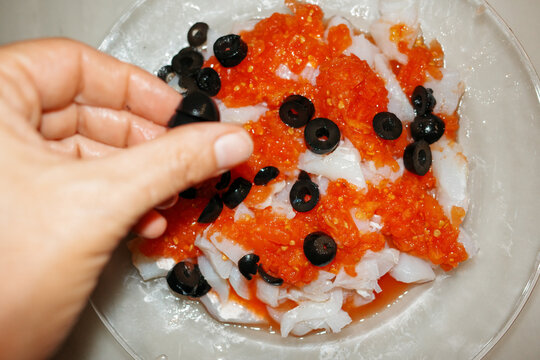 Preparing food. Cod with tomato and olives. Direct flash