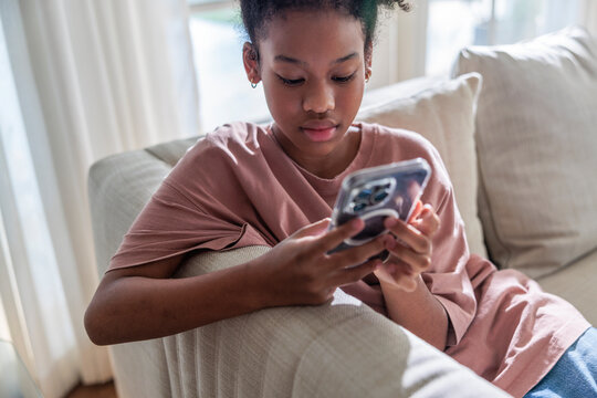 Girl sitting on a sofa and watching at her phone